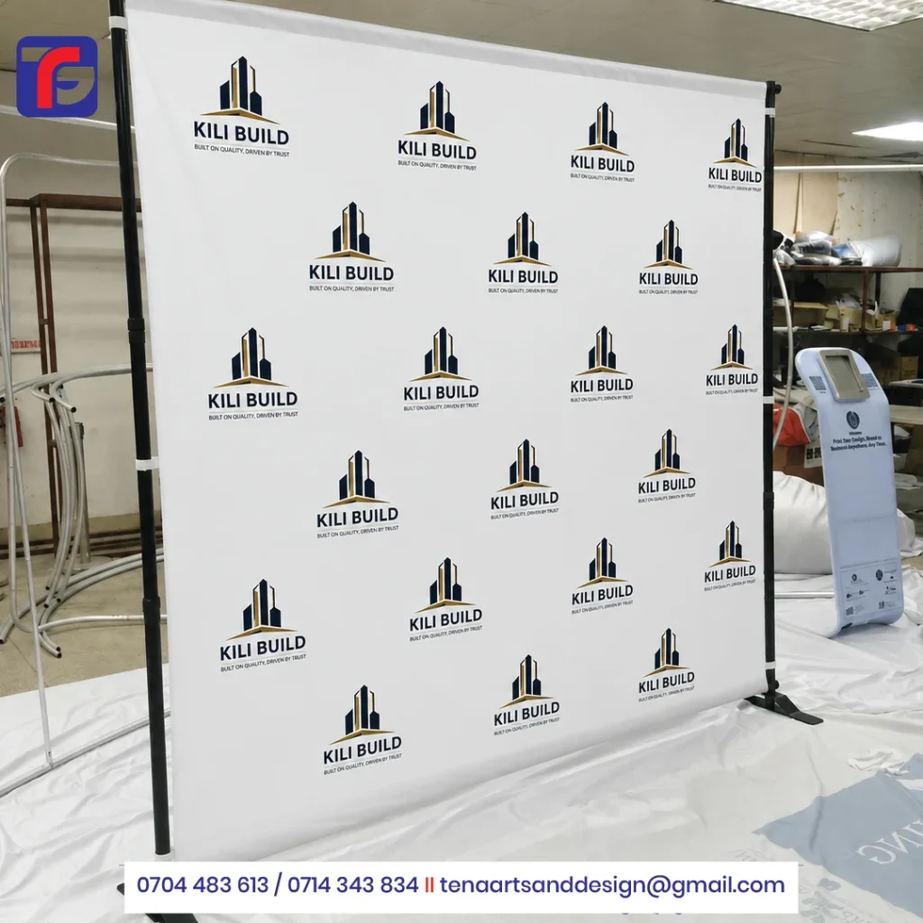 White step and repeat backdrop with navy and gold KILI BUILD logos, black support uprights and floor feet.